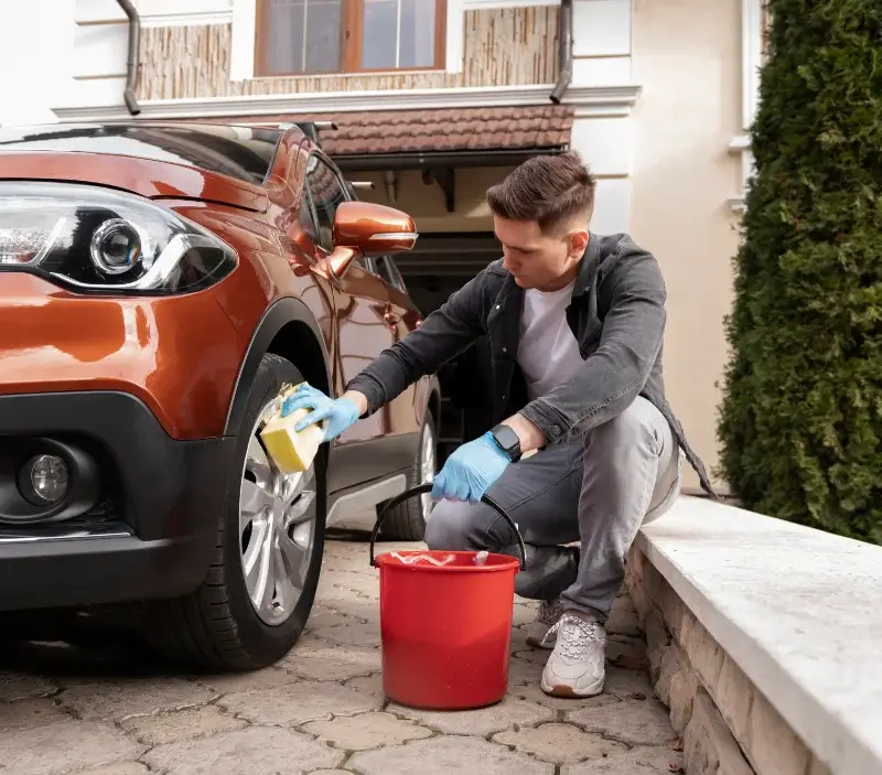 Lavage auto à domicile Bréhain-la-Ville : professionnel intervenant sur un véhicule